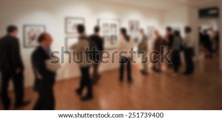 People at photography gallery, generic background. Intentionally blurred editing post production. Poeple, works and location not recognizable.