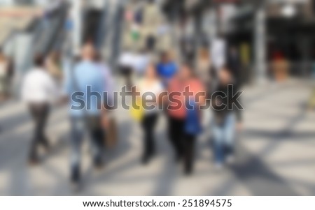 People walk, background. Intentionally blurred editing post production. Humans not recognizable.