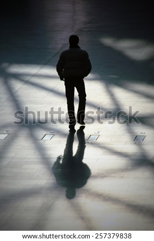 Silhouette of a man walking, generic background. Intentionally blurred editing post production.
