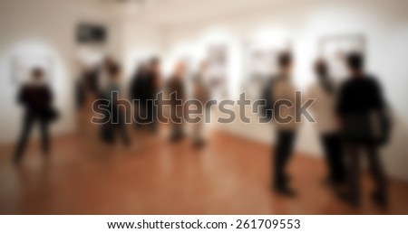 People visiting a photography exhibition, background. Intentionally blurred editing post production.