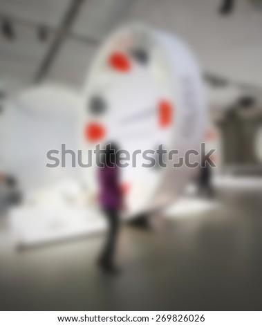 Woman at trade show, generic background. Intentionally blurred editing post production.