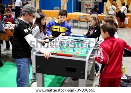 MILAN, ITALY - OCT. 16: Children playing table football at Ludica, area dedicated to gaming at Hobby Show, Italian showroom of the fine arts and manual creativity October 16, 2009 in Milan, Italy.