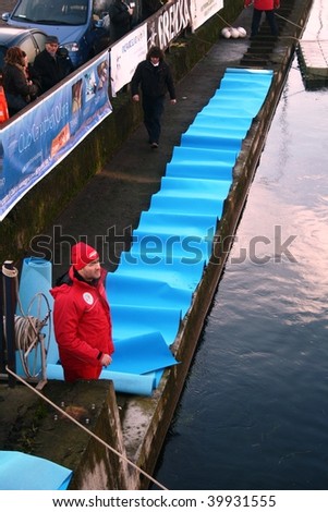 MILAN, ITALY - JAN. 26: One of the event organizers checks security measures before historical winter swim endeavor at Naviglio Grande, main canal of the city January 26, 2009 in Milan, Italy.