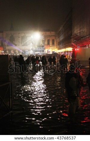 VENICE, ITALY - JAN. 01: Crowd dance in the water during New year\'s day party at San Marco square even with high tide arriving January 01, 2010 in Venice, Italy.