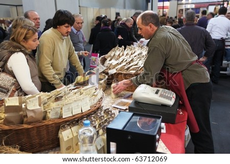 TORINO, ITALY - OCT. 24: People buy local food products in exhibition at Salone del Gusto, international fair of tastes and slow food October 24, 2010 in Torino, Italy.