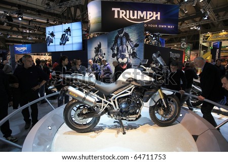 MILAN, ITALY - NOV. 03: People look at Triumph new motorcycle at EICMA, 68th International Motorcycle Exhibition November 03, 2010 in Milan, Italy.