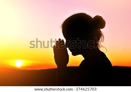 she folded her hands in prayer. beautiful sunset.