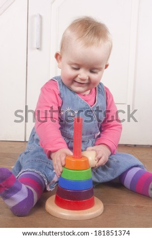 cute baby girl stacking wooden toy rings