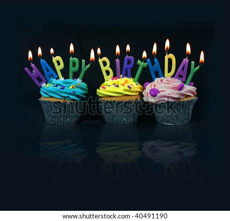 cupcakes spelling out happy birthday on a black background with reflection