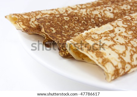 Pancakes or crepes on a white plate close up short depth of field