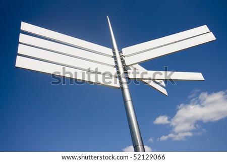 sign pointing in different directions against a blue sky