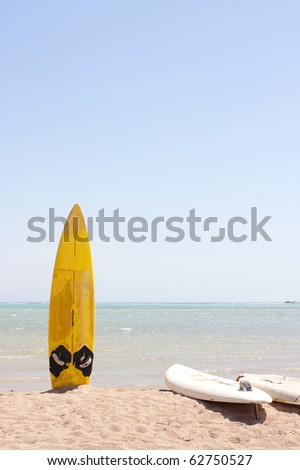 a single surfboard stuck in the sand on a beach in