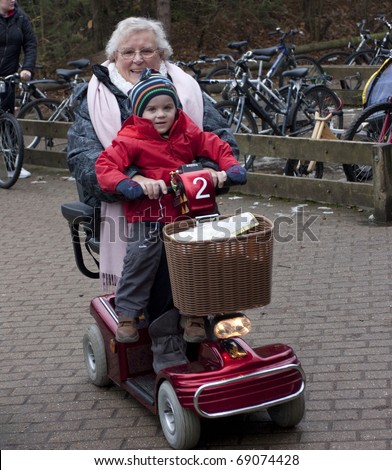 elderly lady riding on a mobility scooter with child