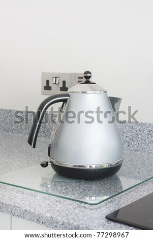 modern grey metal kettle stood on a granite worktop