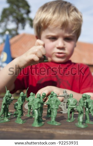 4 year old blonde boy playing toy soldiers