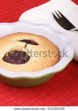 Small plum cake in a pottery cake tin.