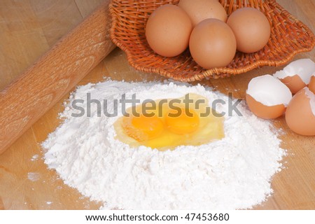 Ingredients to prepare typical italian fresh egg pasta: soft wheat flour, eggs and rolling pin.