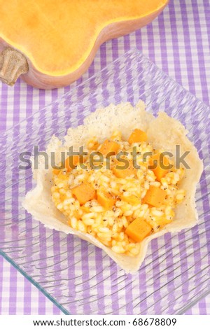 Cheese basket filled with risotto and pumpkin over a glass dish