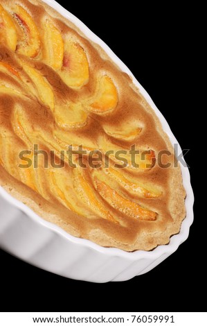 Peach tart in a white pottery cake tin. Isolated on black with clipping path.