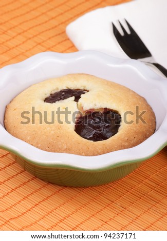 Small plum cake in a pottery cake tin. Selective focus, shallow DOF.