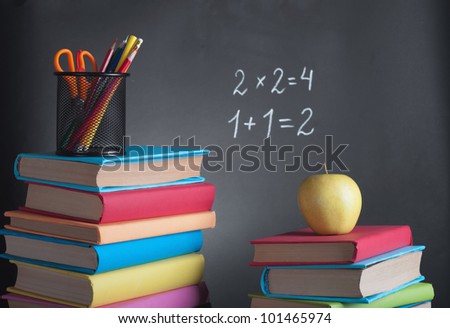 School books with apple on desk