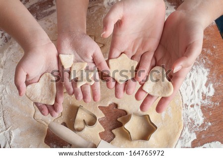 Mother and daughter make biscuits. only the hands