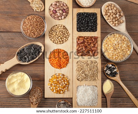 Cereal grains , seeds, beans on wooden background.