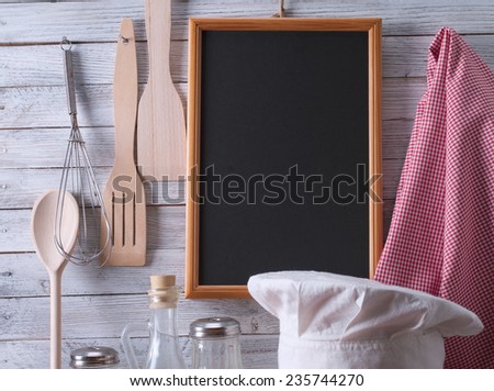 Blackboard on wooden surface and serving spoons