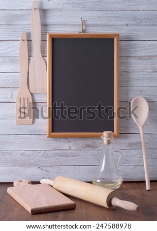 Blackboard on wooden surface and serving spoons