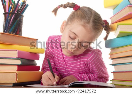 stock photo Blonde happy schoolgirl works on her homework write something