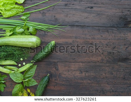 Green vegetables on wooden background (peas, parsley, basil, cucumber, dill, onion ,salad)