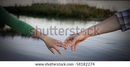 Young hands touching water in background.