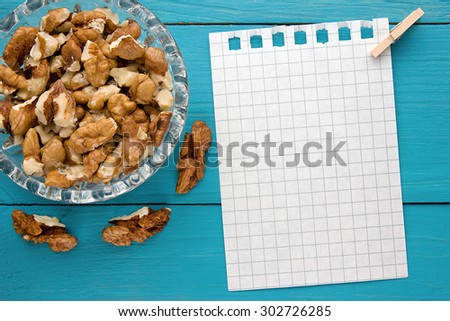 Menu background. Cook book. Recipe notebook with walnuts on turquoise wooden texture