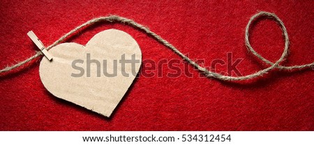 Heart from cardboard on rope with clothespin on red background with the gradient effect. Valentine's day, border design panoramic banner