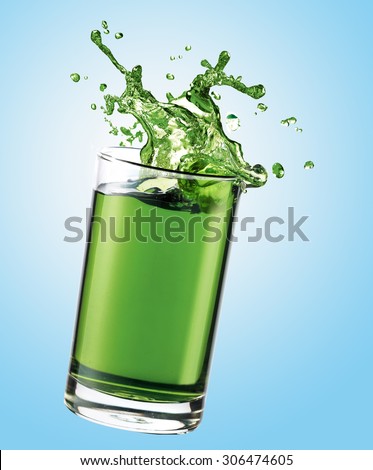 Green juice splashing from glass