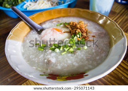 Lovely traditional Thai porridge rice gruel in bowl that is light meal  served with young ginger and garlic