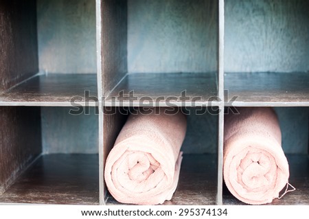The towels rolled up in a storage space ,the simple way to keep towels good looking and ready to use