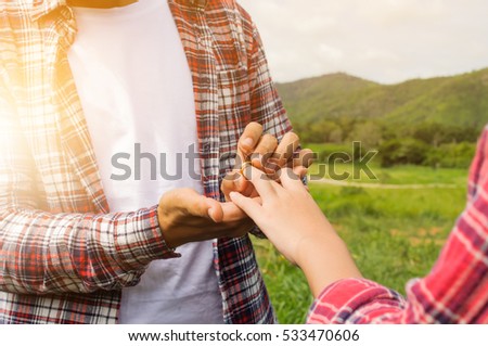 Man wearing wedding engagement ring to lovers in nature. Happy, surprise and very grateful.vintage tone and soft focus