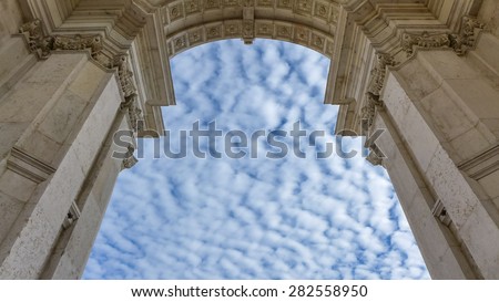 The city gate in Lisbon appears like the gate to heaven in front of these beautiful and fluffy clouds.