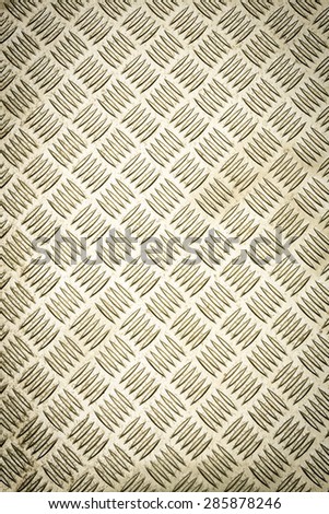 Golden colored Diamond plate, also known as checker plate, tread plate, cross hatch kick plate and Durbar floor plate, wide shot in portrait orientation.