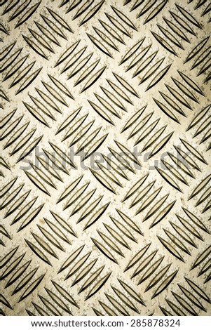 Golden colored Diamond plate, also known as checker plate, tread plate, cross hatch kick plate and Durbar floor plate, closeup iin portrait orientation.
