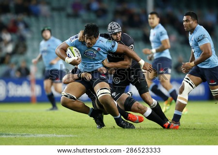 SYDNEY AUSTRALIA-MAY 22, 2015, Will Skelton (blue) breaks the tackles of Sharks players during their Super Rugby match at the Allianz Stadium, Sydney on 22 May, 2015, in Australia