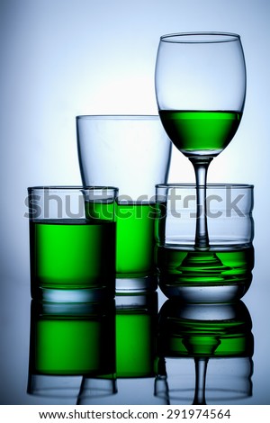 group of glasse whit green water on blue background,and reflex