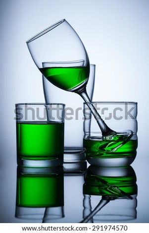 group of glasse with green water on blue background,and reflex