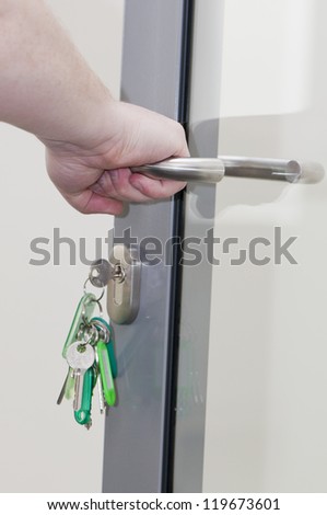 human hand on the door handle, keys in the lock doors