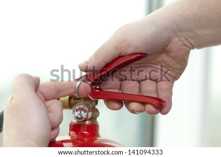 white hand presses the trigger fire extinguisher