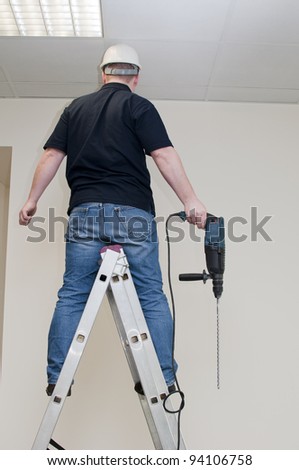 man drill in the wall, employee at work