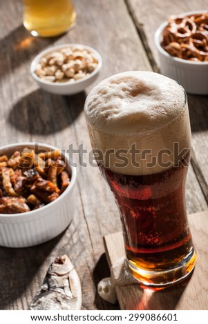Dark beer with snacks on wooden table