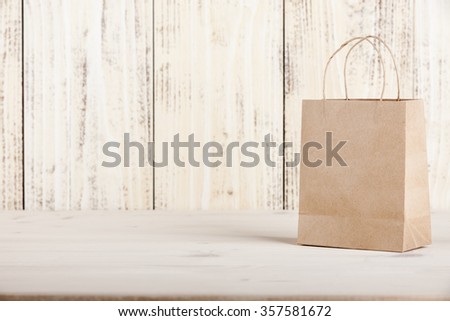 Gift cardboard shopping bag on wooden table