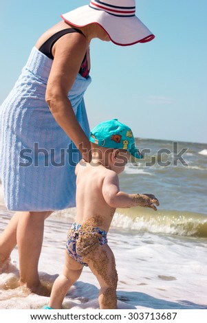 The child learns to swim in the sea comes into the water